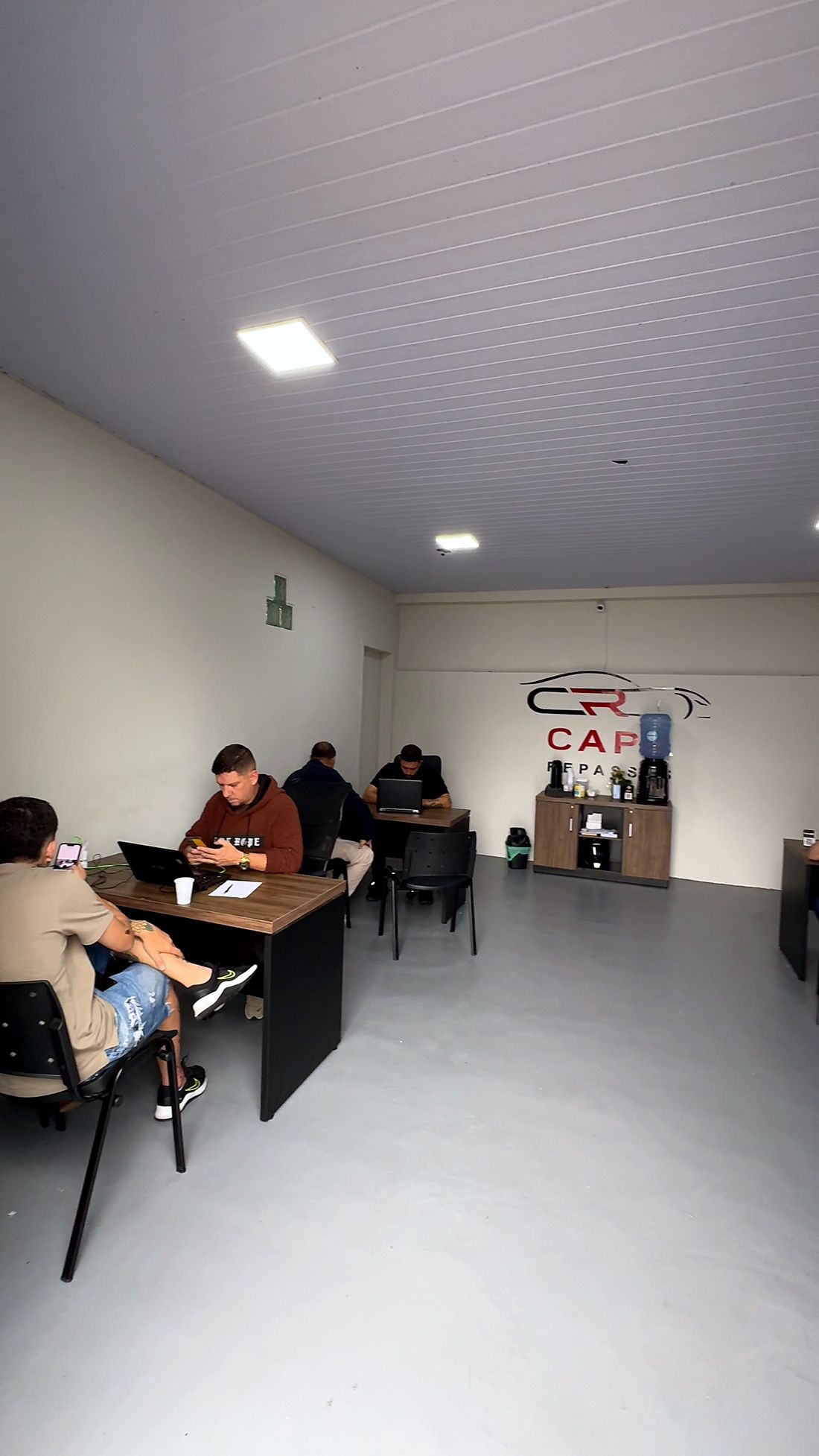Mesas de atendimento com a logo da Capa ao fundo